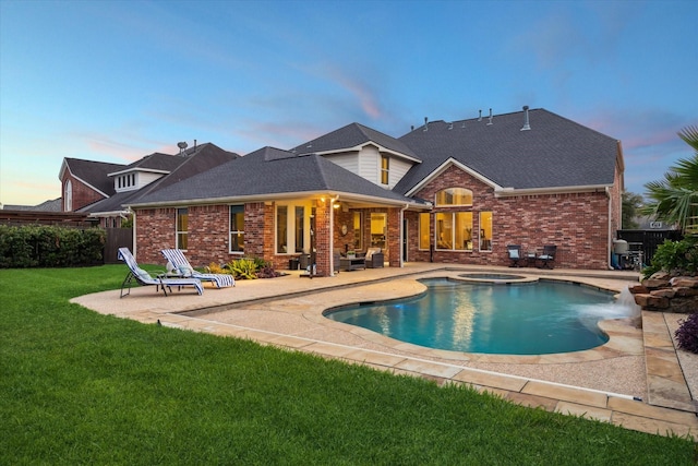 6338 Collina Springs Ct, Houston, TX 77041 - back of property at dusk featuring a patio, brick siding, and a pool with connected hot tub