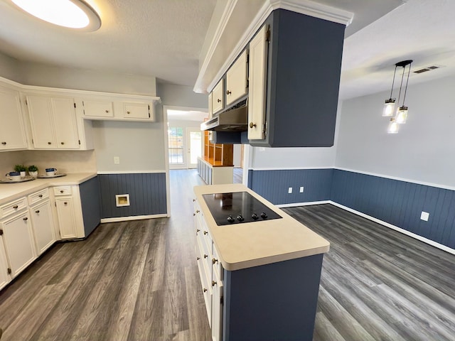 16007 Sailfin St, Crosby, TX 77532 - kitchen with wainscoting, black electric cooktop, under cabinet range hood, dark wood-style floors, and light countertops