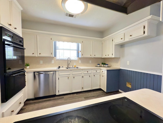 16007 Sailfin St, Crosby, TX 77532 - kitchen featuring stainless steel dishwasher, a sink, dark wood-type flooring, white cabinetry, and a wainscoted wall