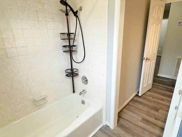 16007 Sailfin St, Crosby, TX 77532 - bathroom with washtub / shower combination, wood finished floors, and baseboards
