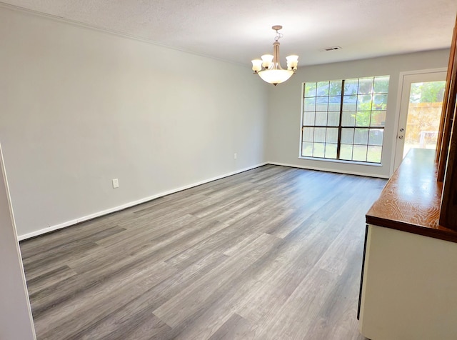 16007 Sailfin St, Crosby, TX 77532 - unfurnished dining area with a chandelier, wood finished floors, and baseboards