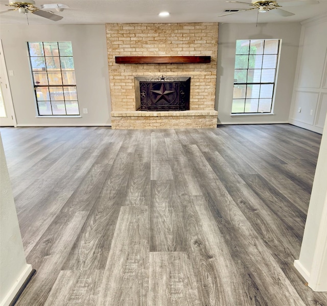 16007 Sailfin St, Crosby, TX 77532 - unfurnished living room featuring ceiling fan, wood finished floors, and a fireplace