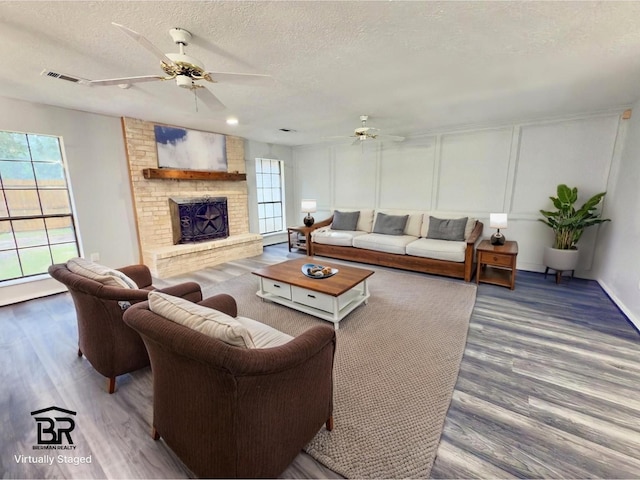 16007 Sailfin St, Crosby, TX 77532 - living room with ceiling fan, a textured ceiling, plenty of natural light, wood finished floors, and a decorative wall