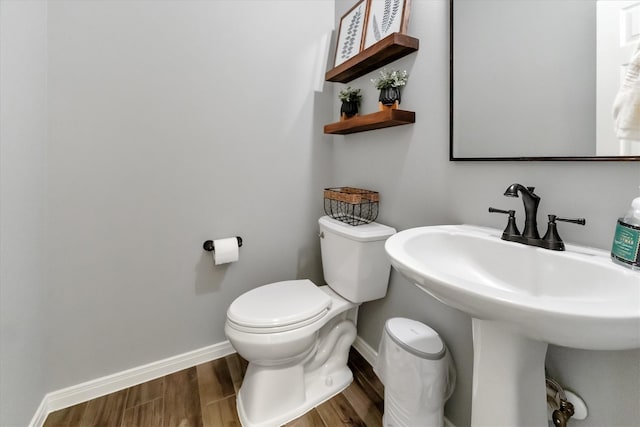 31 Brywood Pl, The Woodlands, TX 77382 - half bathroom with toilet, baseboards, wood finished floors, and a sink