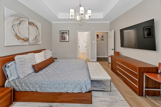 31 Brywood Pl, The Woodlands, TX 77382 - bedroom featuring light wood finished floors, a tray ceiling, a chandelier, and crown molding