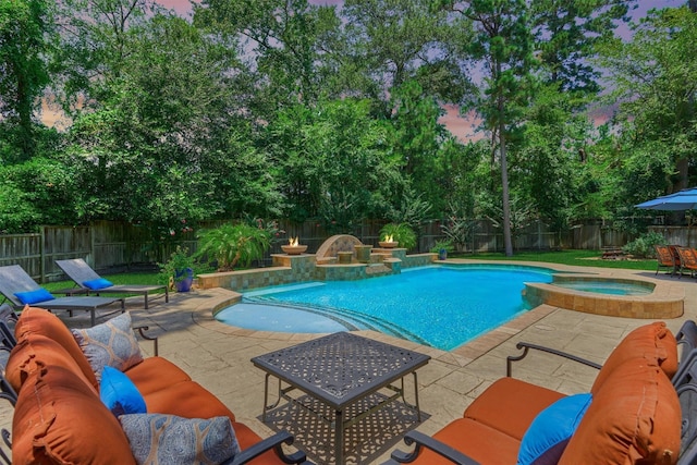 31 Brywood Pl, The Woodlands, TX 77382 - pool at dusk featuring a fenced backyard, a patio area, a pool with connected hot tub, and view of scattered trees