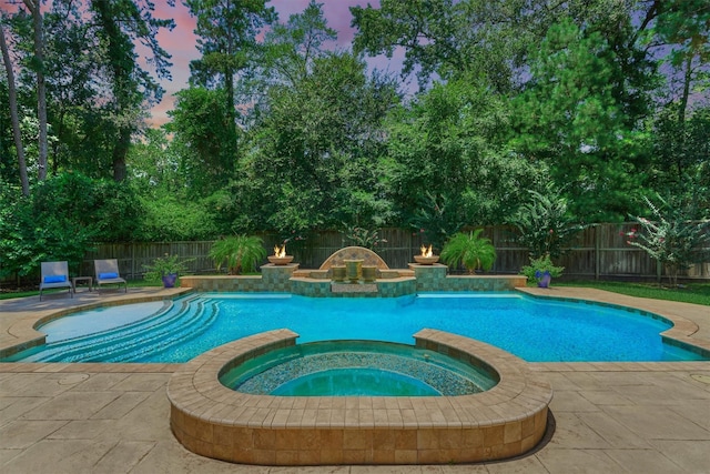 31 Brywood Pl, The Woodlands, TX 77382 - pool at dusk with a pool with connected hot tub, a fenced backyard, and a patio