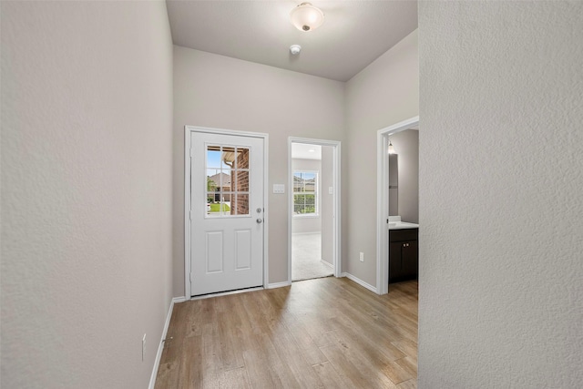513 Bonnerville Ln, Magnolia, TX 77354 - entryway featuring light wood finished floors, baseboards, and a textured wall