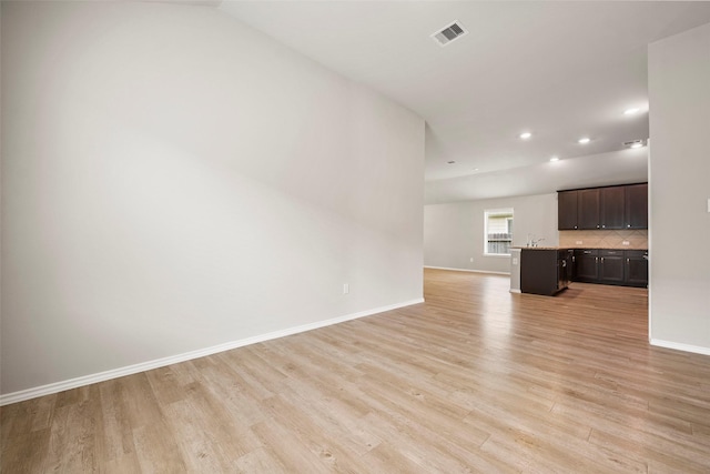 513 Bonnerville Ln, Magnolia, TX 77354 - unfurnished living room with light wood-style flooring, baseboards, recessed lighting, and a sink