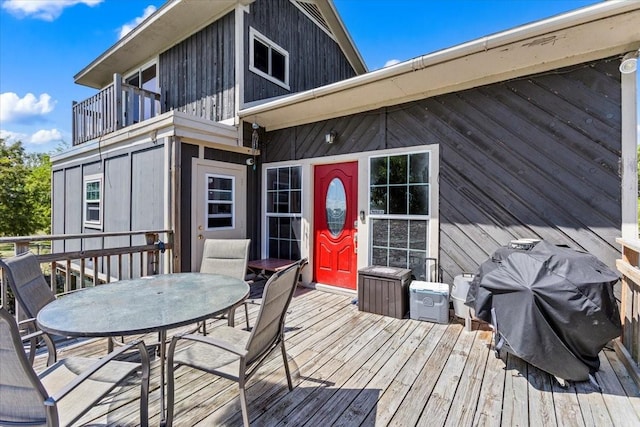 wooden terrace featuring outdoor dining space and area for grilling