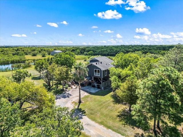 aerial view of property and surrounding area featuring a forest and a large body of water