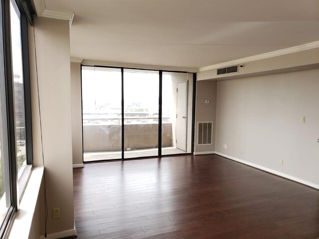 3525 Sage Rd Unit 704, Houston, TX 77056 - spare room featuring crown molding, dark wood-style flooring, expansive windows, and baseboards