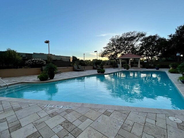 3525 Sage Rd Unit 704, Houston, TX 77056 - pool at dusk with a gazebo, a patio, and a community pool