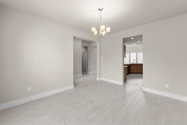18423 Windy Knoll Way, Houston, TX 77084 - empty room featuring a chandelier, a sink, light wood-style floors, and baseboards