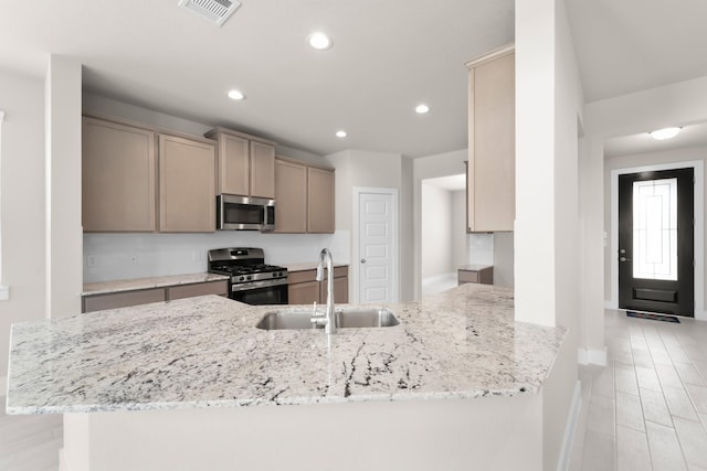 18423 Windy Knoll Way, Houston, TX 77084 - kitchen with appliances with stainless steel finishes, a sink, light stone counters, recessed lighting, and a peninsula