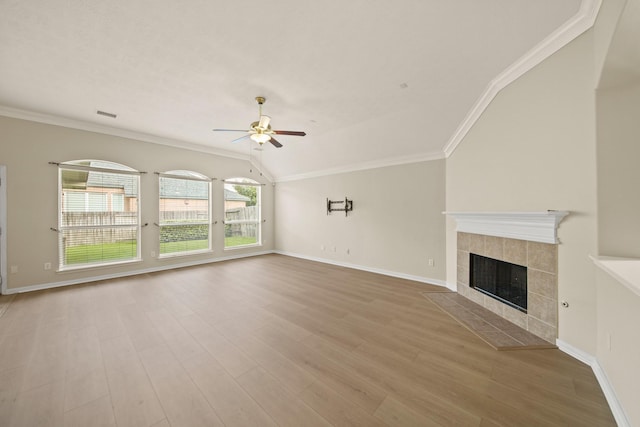 1910 Edenfield Ln, Sugar Land, TX 77479 - unfurnished living room featuring ceiling fan, ornamental molding, a tiled fireplace, wood finished floors, and baseboards
