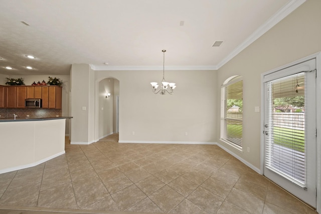 1910 Edenfield Ln, Sugar Land, TX 77479 - kitchen featuring stainless steel microwave, arched walkways, a chandelier, ornamental molding, and decorative backsplash