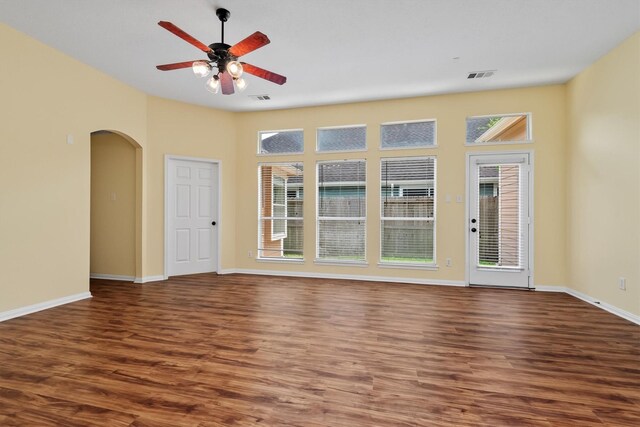 13014 Vivienne Westmoreland Dr, Cypress, TX 77429 - unfurnished room with healthy amount of natural light, arched walkways, and dark wood-style floors