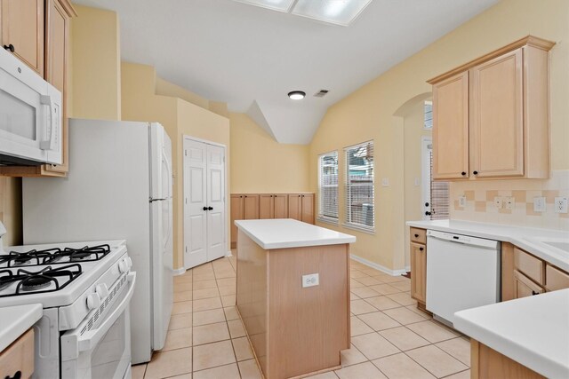 13014 Vivienne Westmoreland Dr, Cypress, TX 77429 - kitchen featuring white appliances, a center island, light brown cabinets, arched walkways, and light tile patterned floors