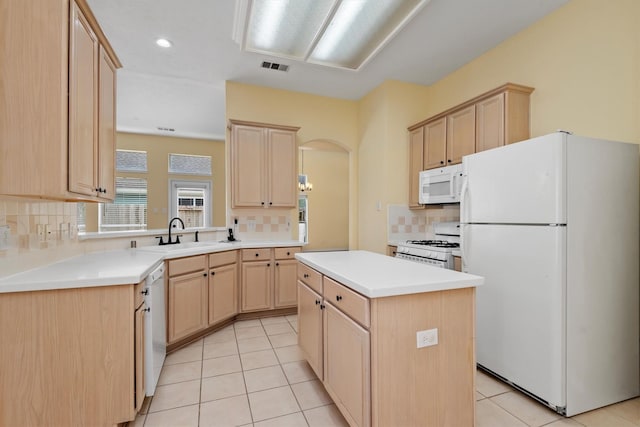 13014 Vivienne Westmoreland Dr, Cypress, TX 77429 - kitchen with white appliances, a sink, light brown cabinets, arched walkways, and tasteful backsplash