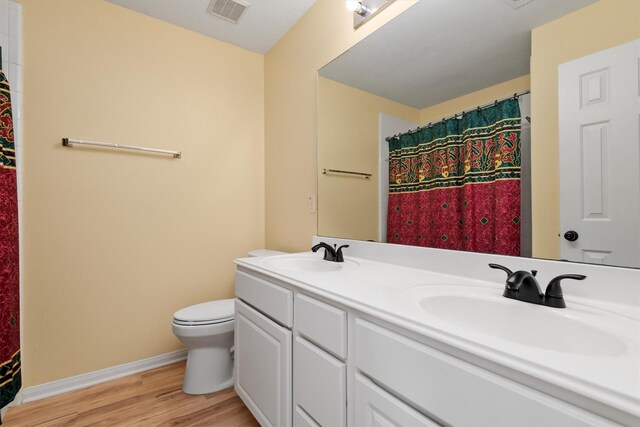 13014 Vivienne Westmoreland Dr, Cypress, TX 77429 - full bath featuring wood finished floors, toilet, baseboards, double vanity, and a shower with shower curtain