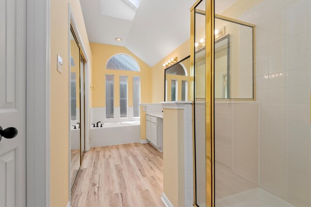 13014 Vivienne Westmoreland Dr, Cypress, TX 77429 - full bath with lofted ceiling, a shower stall, vanity, a bath, and wood finished floors