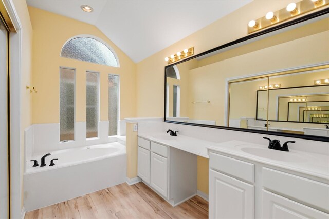 13014 Vivienne Westmoreland Dr, Cypress, TX 77429 - full bathroom with vaulted ceiling, a garden tub, wood finished floors, double vanity, and recessed lighting