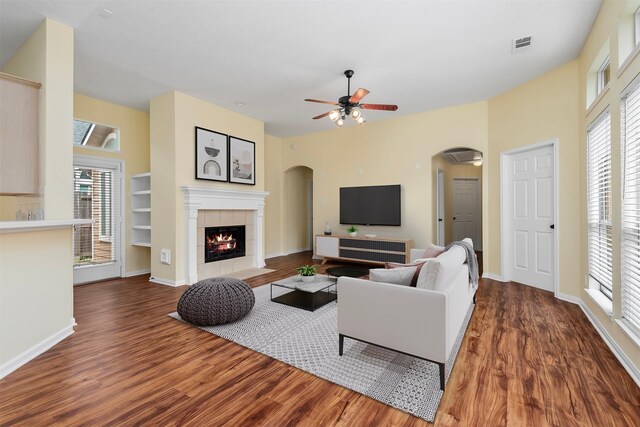 13014 Vivienne Westmoreland Dr, Cypress, TX 77429 - living room featuring arched walkways, wood finished floors, a ceiling fan, and a fireplace