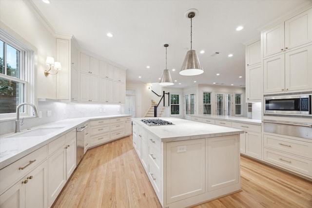 3707 Jardin St, Houston, TX 77005 - kitchen with a warming drawer, a sink, appliances with stainless steel finishes, a center island, and light wood-style flooring