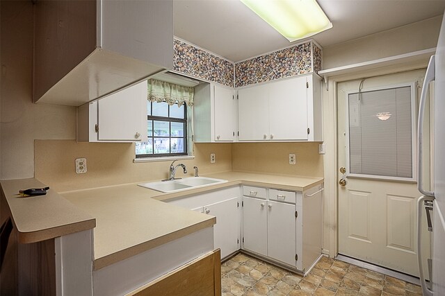 9385 Shepherd Dr, Beaumont, TX 77707 - kitchen with a sink, white cabinets, light countertops, and light stone finish flooring