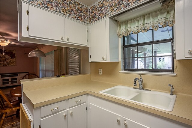 9385 Shepherd Dr, Beaumont, TX 77707 - kitchen featuring a sink, light countertops, white cabinets, ceiling fan, and a peninsula