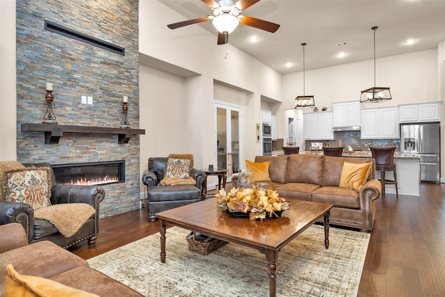15527 Salmon Springs Dr, Conroe, TX 77302 - living room featuring a high ceiling, ceiling fan, dark wood finished floors, a stone fireplace, and recessed lighting