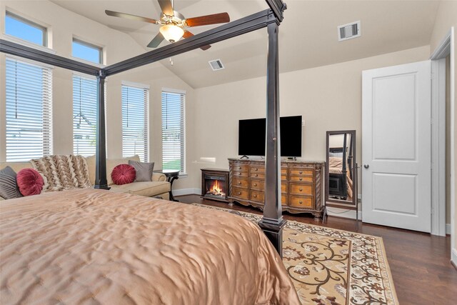 15527 Salmon Springs Dr, Conroe, TX 77302 - bedroom featuring dark wood finished floors, vaulted ceiling, baseboards, ceiling fan, and a lit fireplace