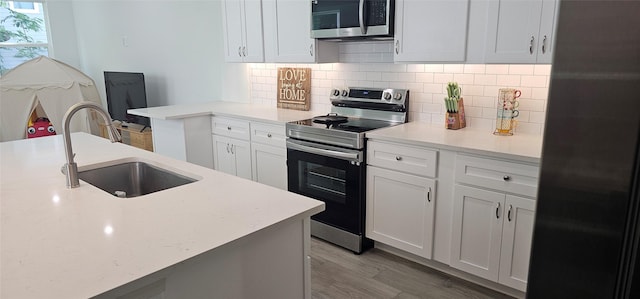 11378 Underwood St, Willis, TX 77318 - kitchen featuring stainless steel appliances, a sink, light countertops, and backsplash