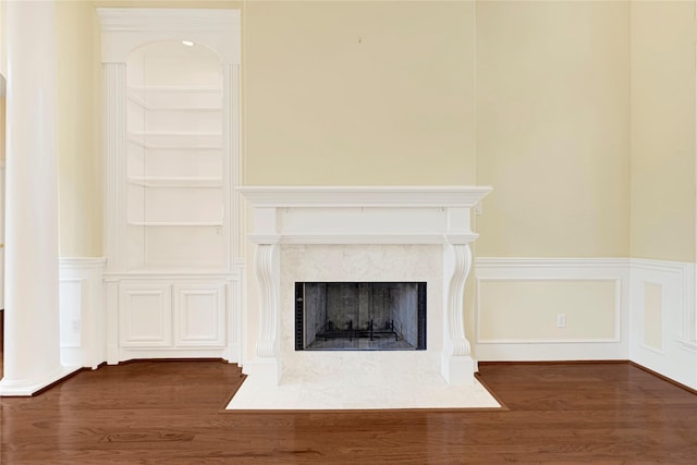 16506 Emilia Ct, Spring, TX 77379 - detailed view of wood finished floors, wainscoting, a fireplace, built in features, and a decorative wall