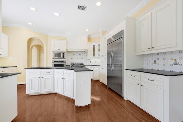 16506 Emilia Ct, Spring, TX 77379 - kitchen featuring built in appliances, dark countertops, white cabinetry, recessed lighting, and crown molding