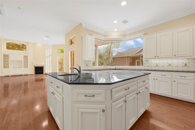 16506 Emilia Ct, Spring, TX 77379 - kitchen with a center island, wood finished floors, a fireplace, decorative backsplash, and recessed lighting