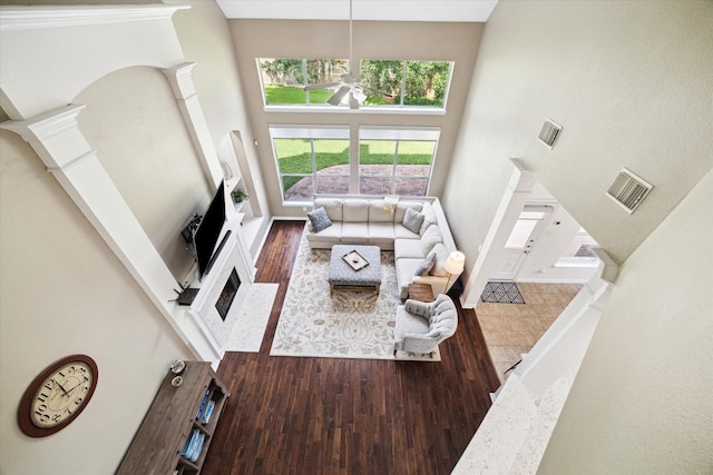 7327 Crescent Bridge Ct, Humble, TX 77396 - living room featuring a towering ceiling, wood finished floors, a ceiling fan, a fireplace, and baseboards