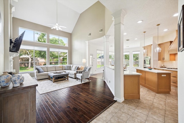 7327 Crescent Bridge Ct, Humble, TX 77396 - living room featuring decorative columns, ceiling fan, high vaulted ceiling, recessed lighting, and light wood-style floors