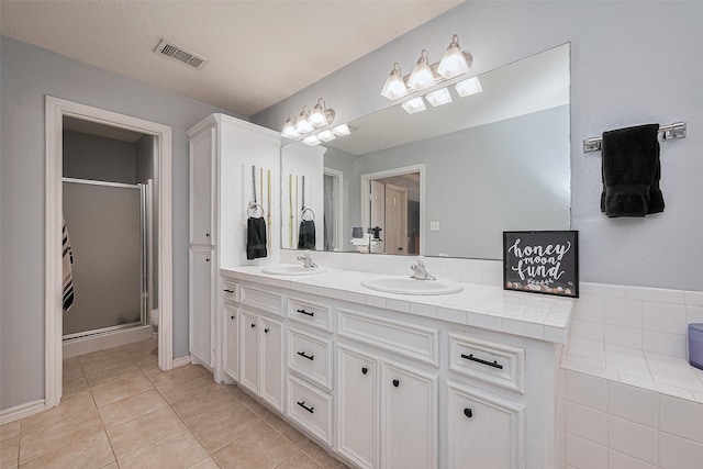 109 Moonspinner, Conroe, TX 77356 - full bathroom featuring double vanity, tile patterned floors, and a shower stall