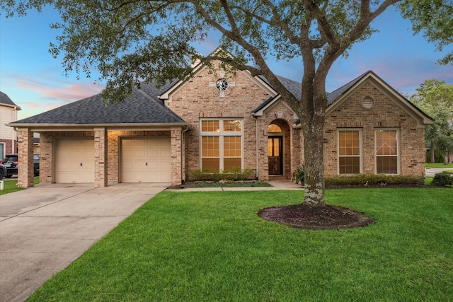 1044 Cayman Bend Ln, League City, TX 77573 - traditional home featuring a shingled roof, an attached garage, driveway, a front yard, and brick siding