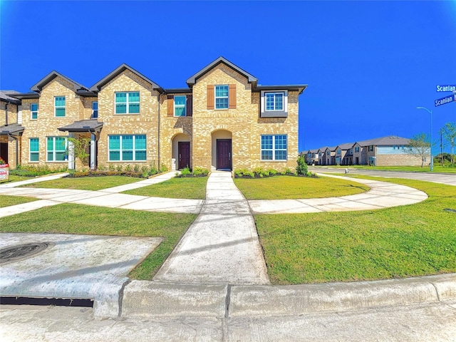 view of front of home featuring a front lawn and brick siding