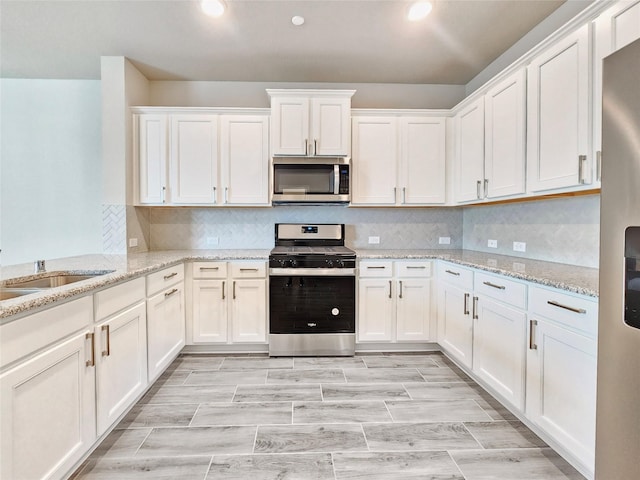 kitchen with stainless steel appliances, white cabinets, recessed lighting, tasteful backsplash, and a sink