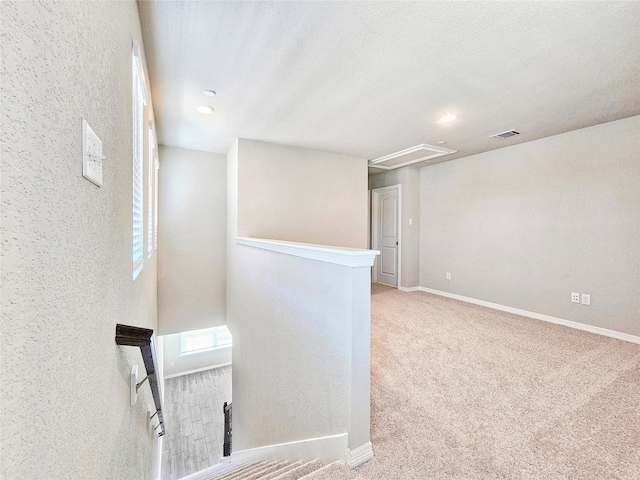 carpeted spare room featuring attic access, baseboards, and recessed lighting