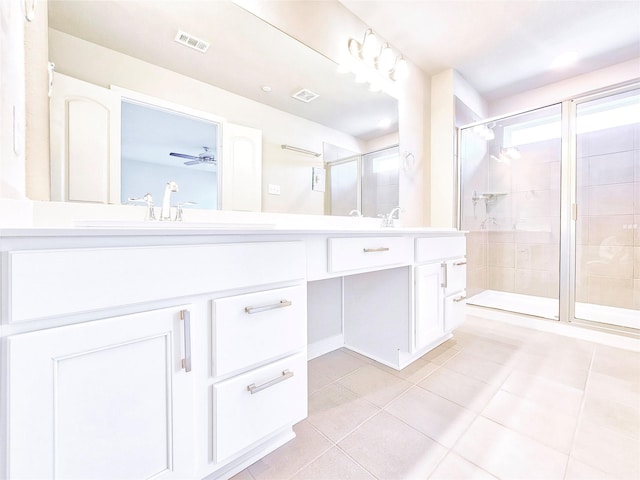 bathroom featuring tile patterned flooring, a shower stall, and double vanity