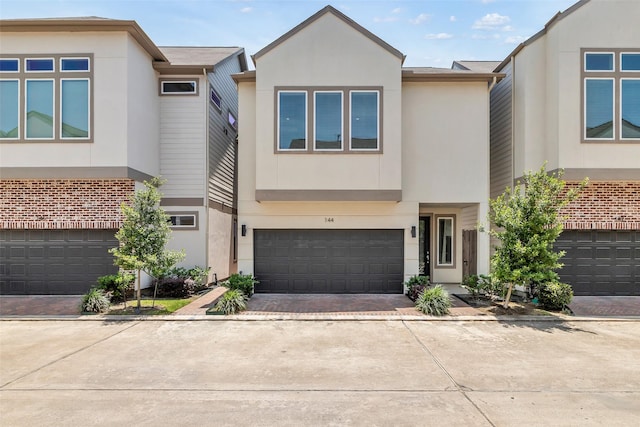 144 Knightsbridge Park Ln, Houston, TX 77018 - view of property featuring an attached garage, driveway, and stucco siding