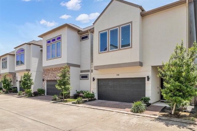 144 Knightsbridge Park Ln, Houston, TX 77018 - view of property featuring an attached garage, stucco siding, and driveway