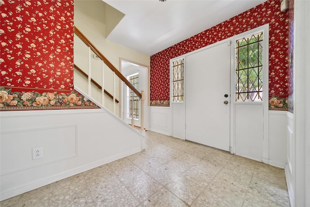 4822 Droddy St, Houston, TX 77091 - entrance foyer featuring wallpapered walls, wainscoting, stairway, a decorative wall, and tile patterned floors