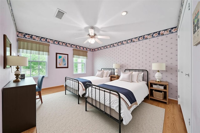 4822 Droddy St, Houston, TX 77091 - bedroom with light wood finished floors, baseboards, wallpapered walls, and ceiling fan