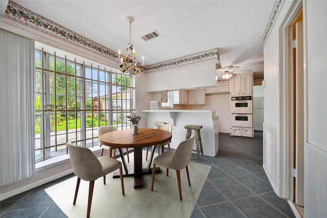 4822 Droddy St, Houston, TX 77091 - dining space featuring a chandelier, dark tile patterned floors, ceiling fan, and a textured ceiling